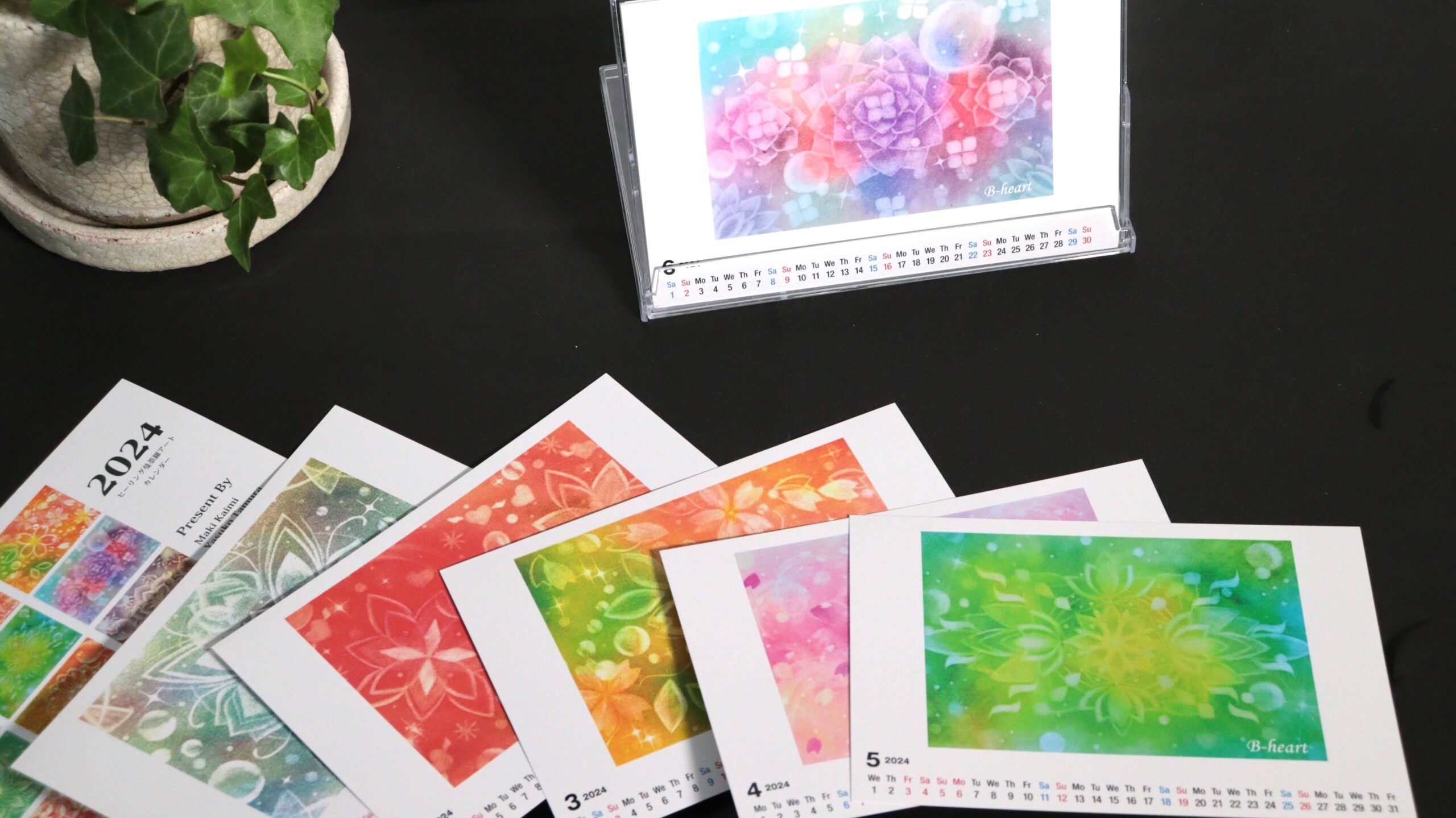 卓上カレンダースタンドに入れた6月のポストカードサイズカレンダー。6月は中央に紫のアジサイが描かれたパステルアート。用紙の下の方に6月の曜日と日付・クリアケースに入れられて。